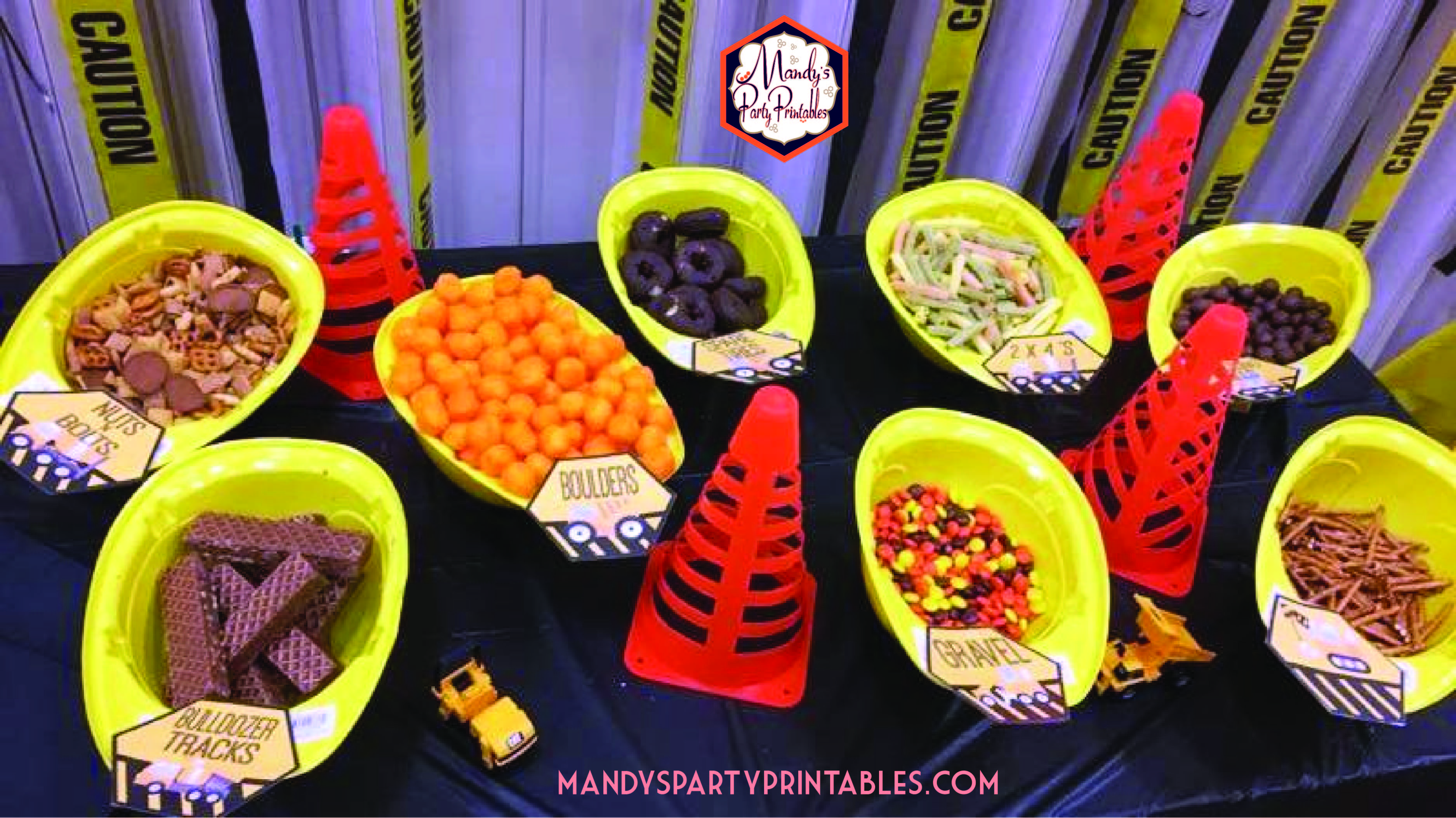 Food table with upside down hard hats filled with food. Food labels for the food "Bulldozer Tracks", "Boulders", "Gravel" and more | Mandy's Party Printables