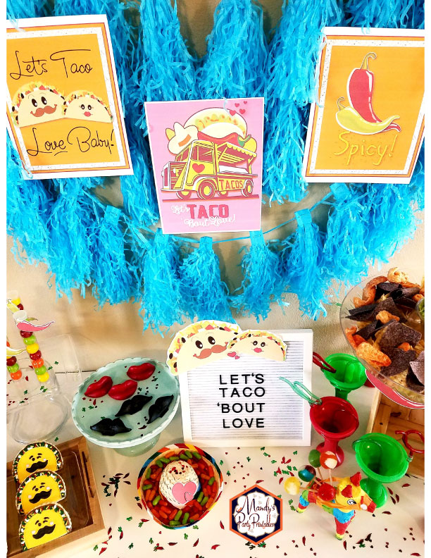 Three party signs on fringed backdrop from a Taco Bout Love Valentine Taco Party | Mandy's Party Printables #valentineparty #tacoparty #tacoboutlove #ilovetacos #MPP #fiesta